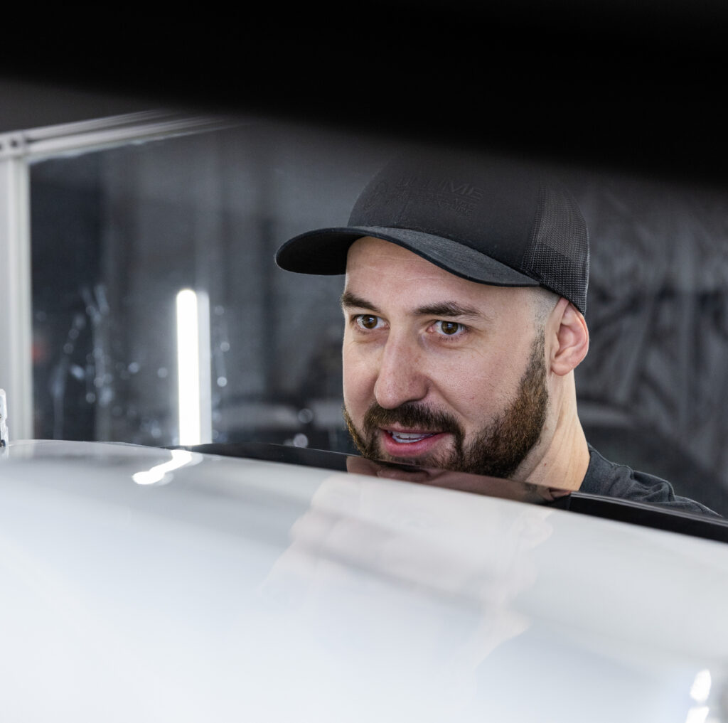 Anthony Landry, propriétaire de Ultime DSP entreprise qui se spécialiste dans le débosselage sans peinture qui regarde les bosses sur une porte pendant qu'il tente de réparer le tout.